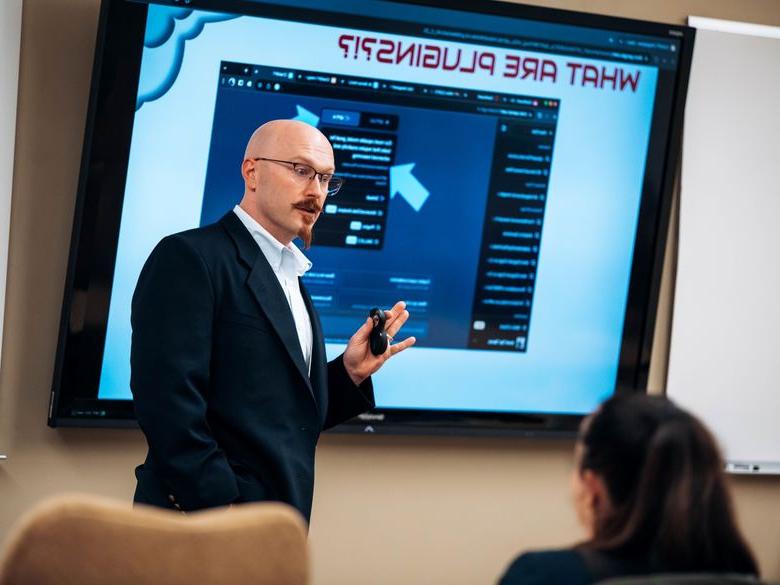 Teacher presenting in front of digital screen